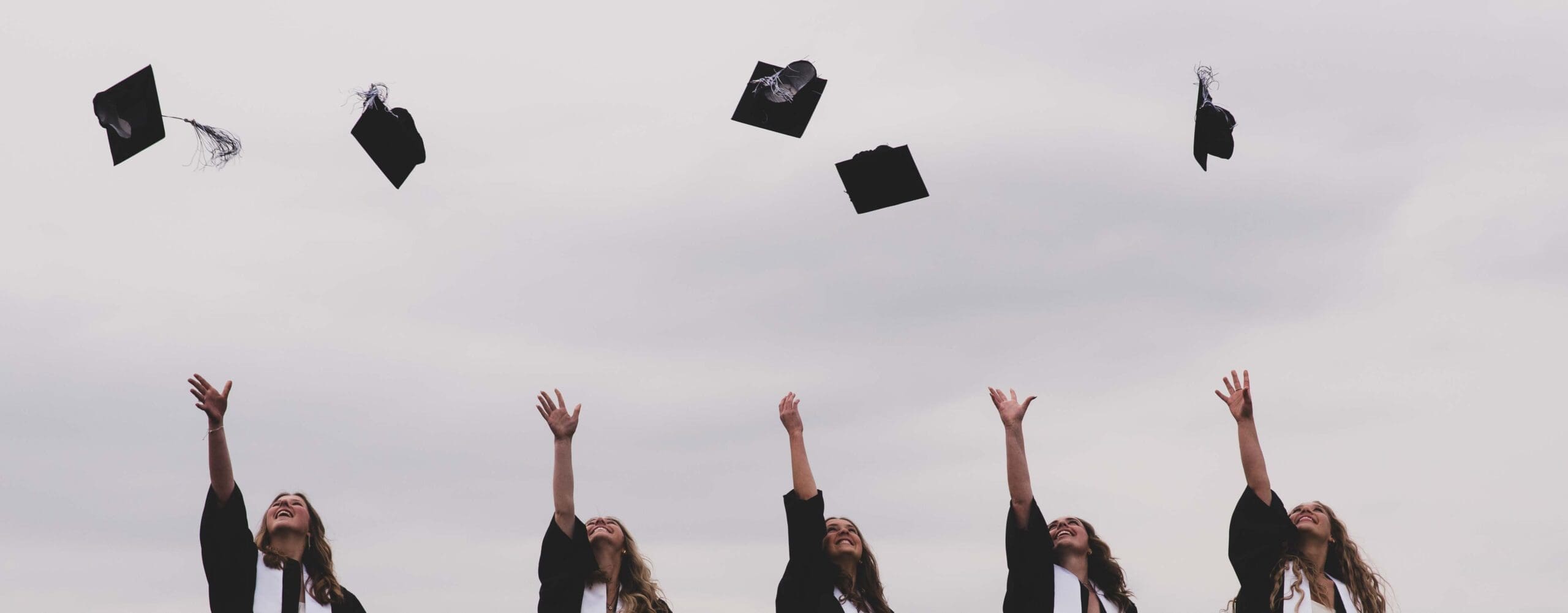 graduation caps thrown in the air by high school seniors